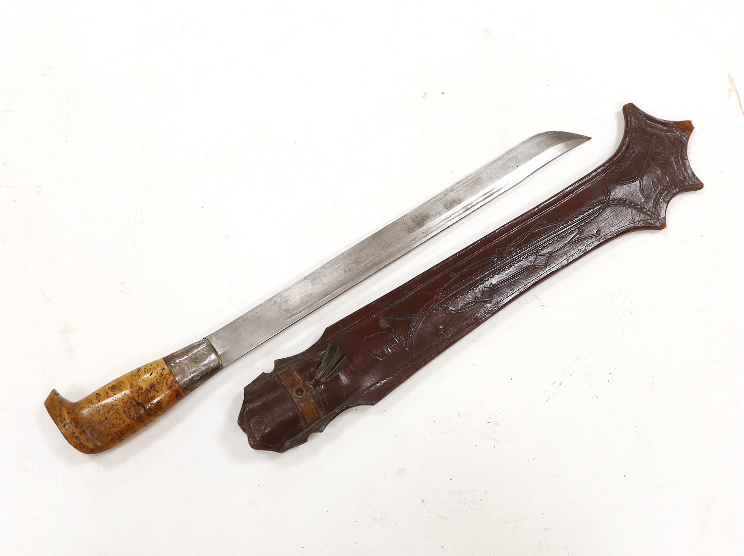 A large Finnish hunting knife, blade dated 1940 and burr wooden handle in its leather sheath, and two Indian kukri in their sheaths